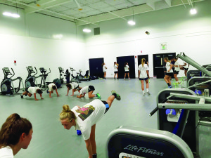 Players on the Varsity Soccer team stretch and exercise their core in the new, spacious Gator Athletics Performance Center.